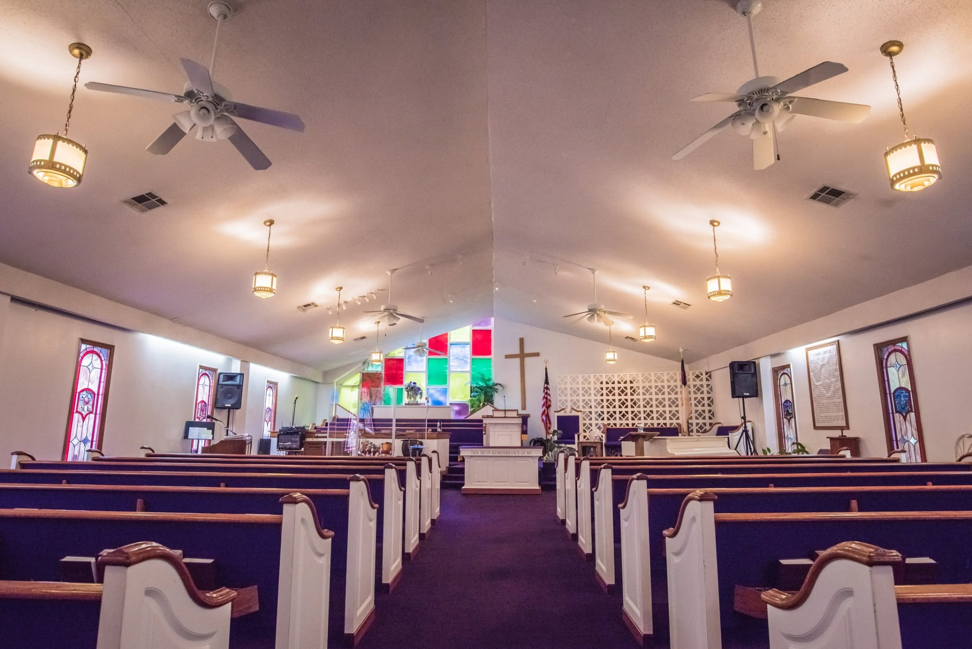 The sanctuary of Concord Baptist Church of Atlanta, with stained glass and purple pews